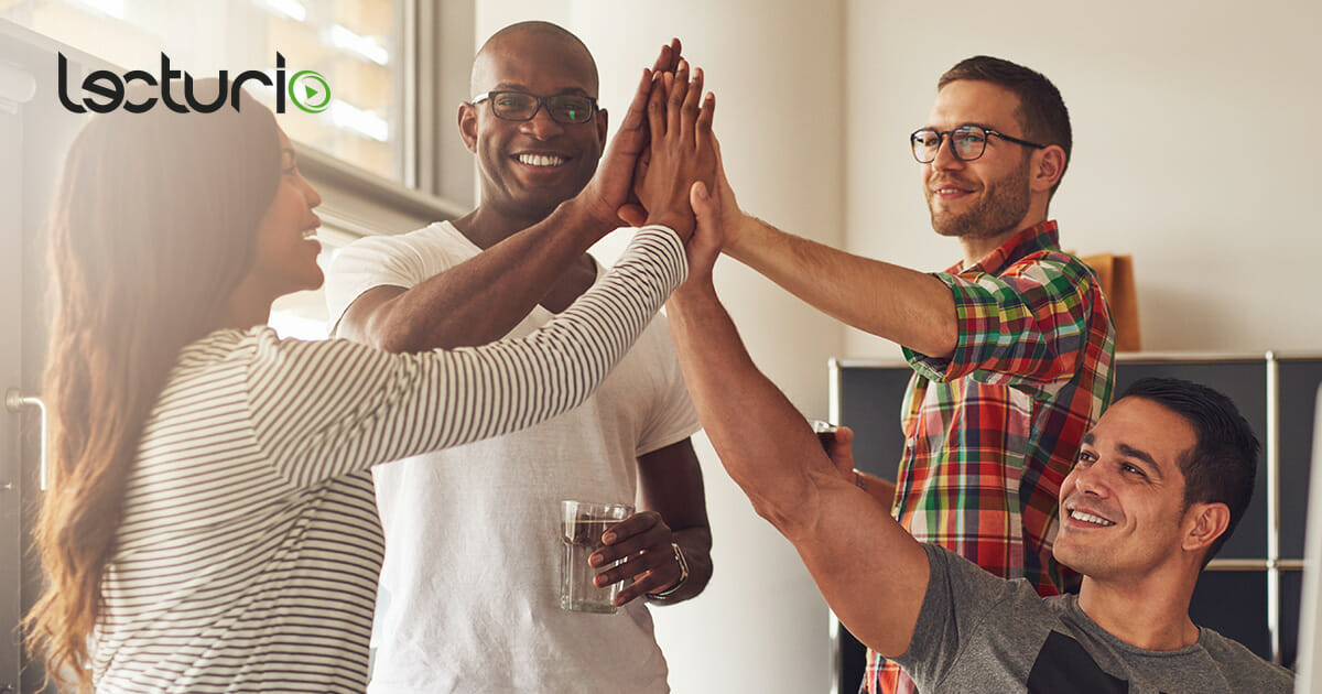 Vier vielfältige Personen geben sich lachend High-Fives während einer Webinar-Herausforderung